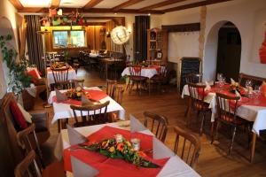 a restaurant with red and white tables and chairs at Antjes Schmankerlhotel und Restaurant in Tröstau