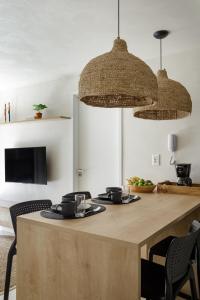 una cocina con una gran mesa de madera con dos platos. en Meu Aconchego à Beira Mar - Exclusivo - Praia Jardim Oceania - João pessoa, en João Pessoa