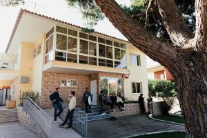 a group of people standing outside of a house at Lisbon Surf Hostel in Carcavelos
