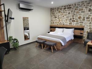 a bedroom with a bed and a stone wall at 1929 Boutique Residences in Ioannina