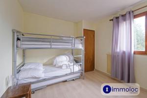 a bedroom with two bunk beds with white sheets at Apartment in Auron 100 meters from the slopes in Auron