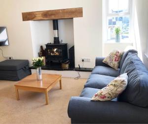 a living room with a blue couch and a fireplace at White Lion Aberporth in Aberporth