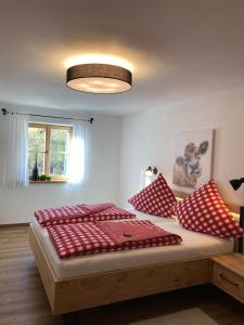 a bedroom with a bed with red and white pillows at Ilgerhof Ferienwohnungen in Oberaudorf