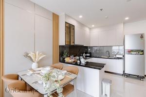 een keuken met een tafel en stoelen in een kamer bij OriGem - Skyview Căn Hộ 2 PN in Thu Dau Mot