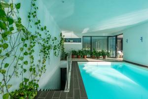 a swimming pool in a house with plants at Lux Villa with heated indoor Pool at Aroeira Sea & Golf Resort - Lisbon in Almada +40 photos