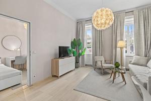 3 Minutes to Metro I At Gürtel I Fast Wifi في فيينا: غرفة معيشة بيضاء مع أريكة وتلفزيون