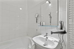 3 Minutes to Metro I At Gürtel I Fast Wifi في فيينا: حمام مع حوض و مرآة و حوض استحمام