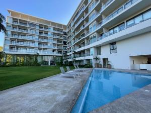 a swimming pool in front of a building at Zantamar Beach Front La Cruz in Cruz de Huanacaxtle