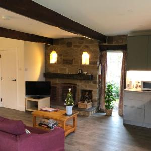 un salon avec un canapé et une cheminée dans l'établissement Locka Old Hall Cottage, à Arkholme