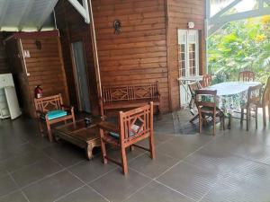 a room with a table and chairs and a table and a table and chairs at les gîtes de la belle fleur Bungalow hibiscus in Le Gosier