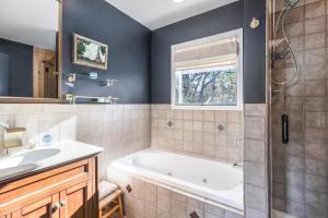 a bathroom with a tub and a sink at Scenic Gem: Waterfront View, Beach Access in Wading River +26 photos