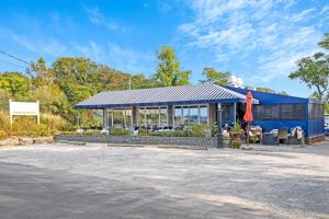a building with a blue roof next to a parking lot at Scenic Gem: Waterfront View, Beach Access in Wading River