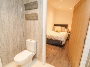 a bathroom with a toilet and a bed in a room at 12A Lake Escape in Carnforth +38 photos