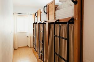 a row of bunk beds in a room at Lisbon Surf Hostel in Carcavelos