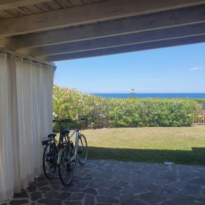 ein paar Fahrräder, die unter einer Veranda geparkt sind. in der Unterkunft Villa Privata Lux con piscina San Teodoro in Porto Ottiolu