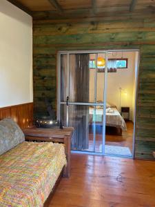 une chambre avec un lit et une porte coulissante en verre dans l'établissement Verde viento, à La Paloma