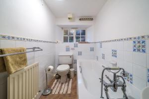 a bathroom with a toilet and a bath tub at Ghyll Foot - At the foot of Place Fell, Ullswater in Patterdale +20 photos