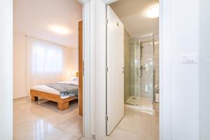 a bedroom with a bed and a walk in shower at Apartment ILUX-1 in Novigrad Dalmatia +10 photos