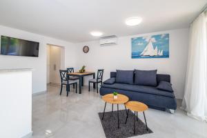 a living room with a blue couch and a table at Apartment ILUX-1 in Novigrad Dalmatia