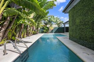 a swimming pool with palm trees next to a house at Miami Gucci Home with Pool & Great Location in Miami