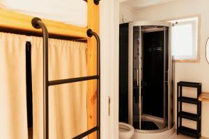 a bathroom with a shower and a toilet in a room at Lisbon Surf Hostel in Carcavelos