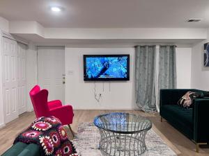 een woonkamer met een bank en een tv aan de muur bij Exclusive Spacious 2 Kings Bed by EWR NYC in Newark