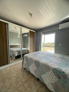 Un dormitorio con una cama y una ventana grande. en Casa no centro de Porto Belo, en Porto Belo