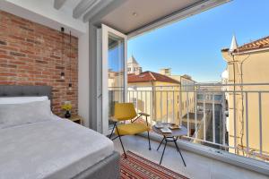 een slaapkamer met een bed en een balkon bij Apartments & Rooms Mareta Exclusive in Zadar