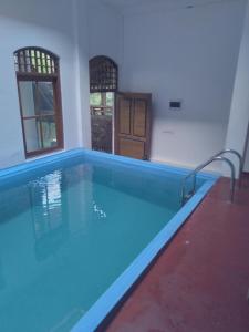 a swimming pool in a house with blue water at Home in the Island in Tangalle