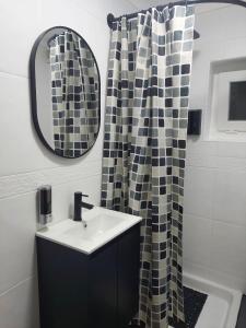a bathroom with a sink and a shower curtain at Vistas al mar, acogedor, completo. Cerca del centro y del puerto. in Bermeo +19 photos