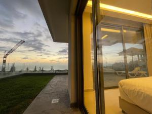 a bedroom with a window looking out at a crane at Tabarja hills in ‘Ayn aş Şughayrah +7 photos