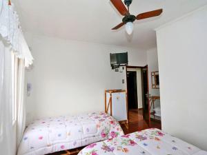 a bedroom with a bed and a ceiling fan at Hotel Pousada Plataforma in Mongaguá