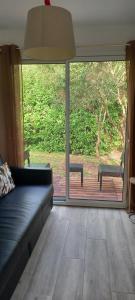 ein Wohnzimmer mit einer Couch und einer Glasschiebetür in der Unterkunft Villa d'Orée, Bordeaux Saint-Aubin-de-Médoc in Saint-Aubin-de-Médoc