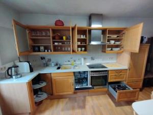 a small kitchen with wooden cabinets and appliances at gemütliches Ferienhaus mit Kamin - Holiday and Nature Wallendorf in Wallendorf +11 photos