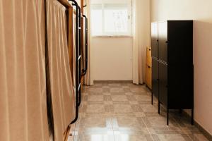 a room with a refrigerator and a tiled floor at Lisbon Surf Hostel in Carcavelos