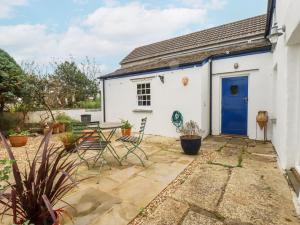 a white cottage with a blue door at Rose Cottage in Falmouth