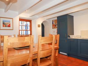 a dining room with a wooden table and chairs at Rose Cottage in Falmouth