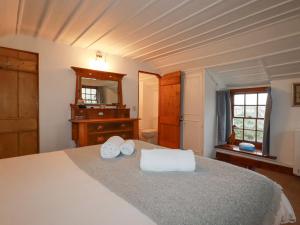 a bedroom with a bed with two towels on it at Rose Cottage in Falmouth