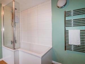 a bathroom with a shower and a bath tub at Rose Cottage in Falmouth +21 photos