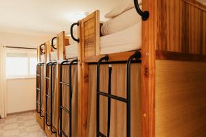 a row of wooden bunk beds in a room at Lisbon Surf Hostel in Carcavelos