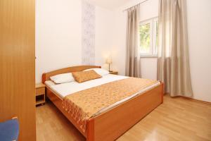 a bedroom with a bed and a window at Apartments Limun Zarok in Baška