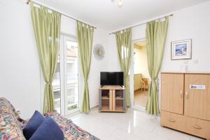 a living room with a couch and a tv at Apartments Limun Zarok in Baška