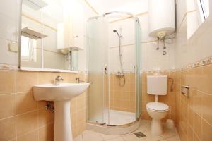 a bathroom with a shower and a toilet and a sink at Apartments Limun Zarok in Baška +66 photos
