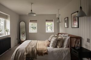 a bedroom with a bed with white sheets and pillows at Luxurious Manor House with Sea Views - Sleeps 10 in Amlwch