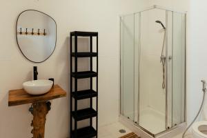 a bathroom with a shower with a sink and a mirror at Lisbon Surf Hostel in Carcavelos