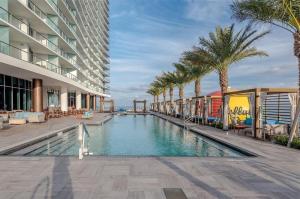 a swimming pool in the middle of a building with palm trees at Corner condo, Wraparound Balcony Ocean and City Views at LYFE Resort in Hollywood