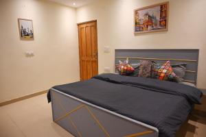 a bedroom with a large bed with blue sheets and pillows at Castle Inn Oasis Homestay in Dehradun +9 photos