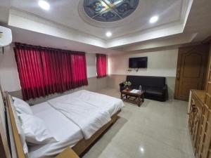 una camera da letto con un letto grande e un divano di Hotel Paradise a Jamnagar