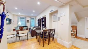 a kitchen and living room with a table and chairs at Newly Renovated 2-bed, Back Bay Near Mgh, Bu, Mit in Boston +12 photos