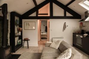 ein Wohnzimmer mit Couch und Küche in der Unterkunft The Bothy - A secluded and romantic rural retreat in Llanddyfnan + 21 Fotos